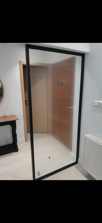 دیوایدر شیشهای فریمدار مشکی با شیشه فلوت (شیاردار) در ورودی سرویس بهداشتی